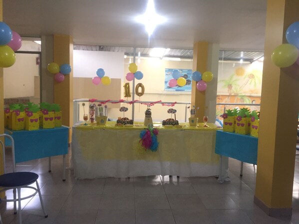 A decorated party table with balloons, a cake, and party favors.