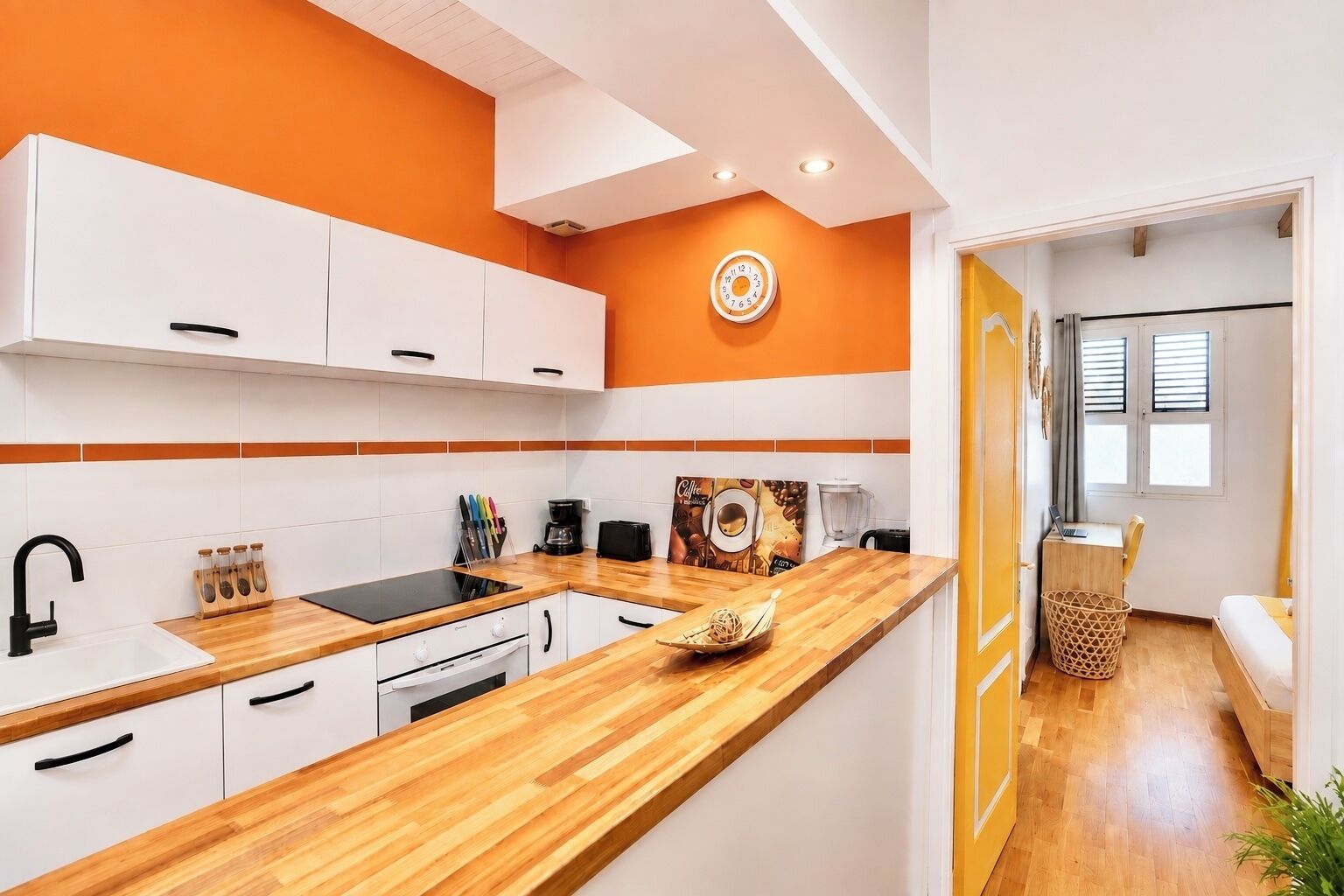 A modern kitchen with white cabinets, a wooden countertop, and a coffee-themed wall art.
