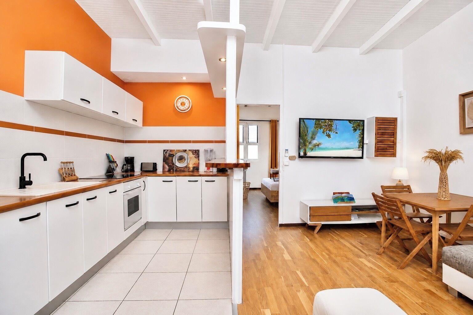 Eine moderne Küche mit weißen Schränken, einer Holz Arbeitsplatte und einem gefliesten Boden.