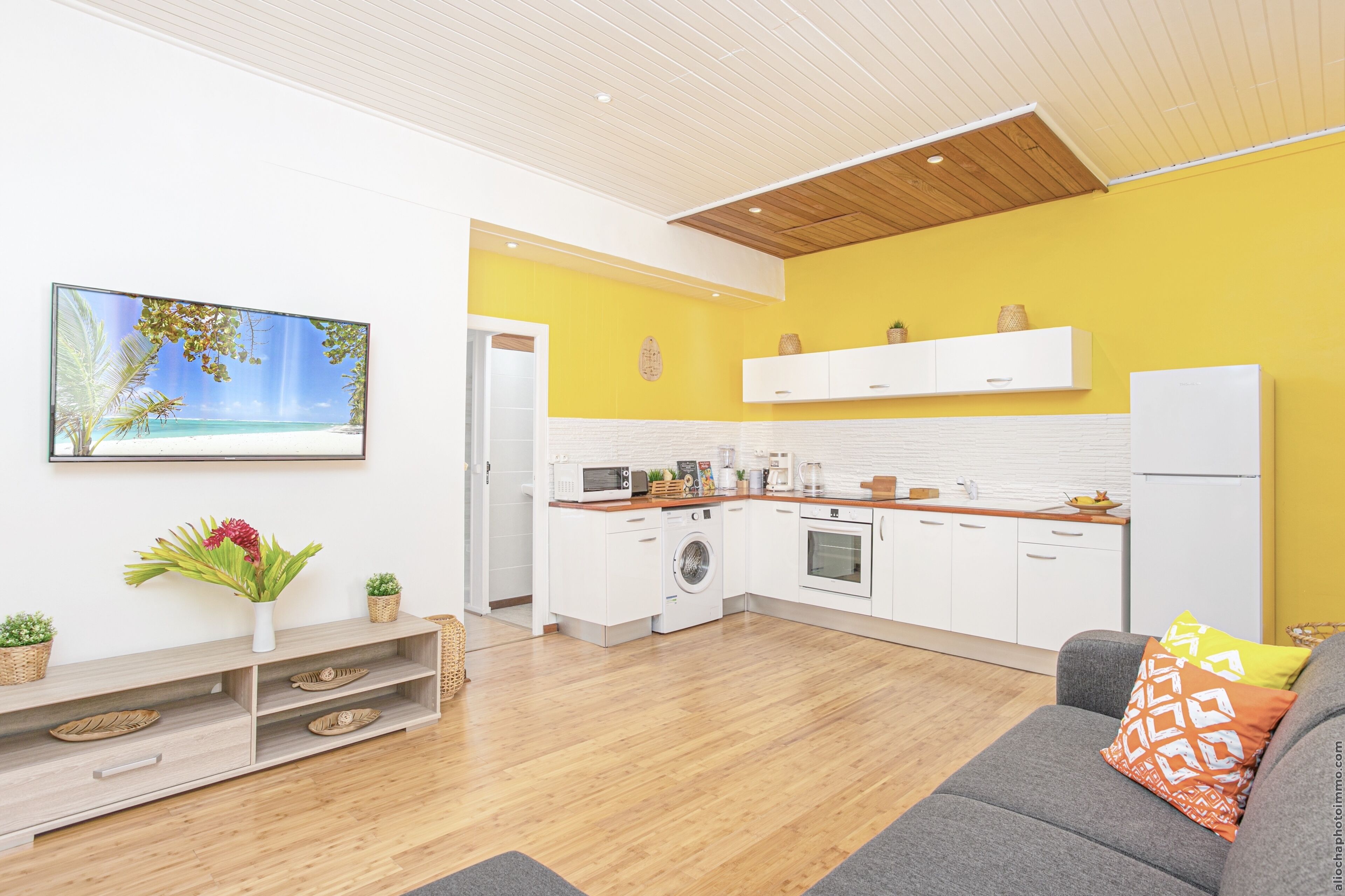 A modern kitchen with white cabinets, a wooden countertop, and a built-in oven.