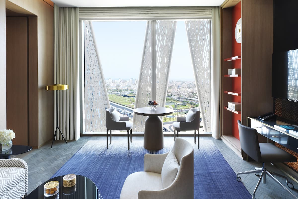 Une chambre d’hôtel moderne avec vue sur la ville, un coin repas et un téléviseur.