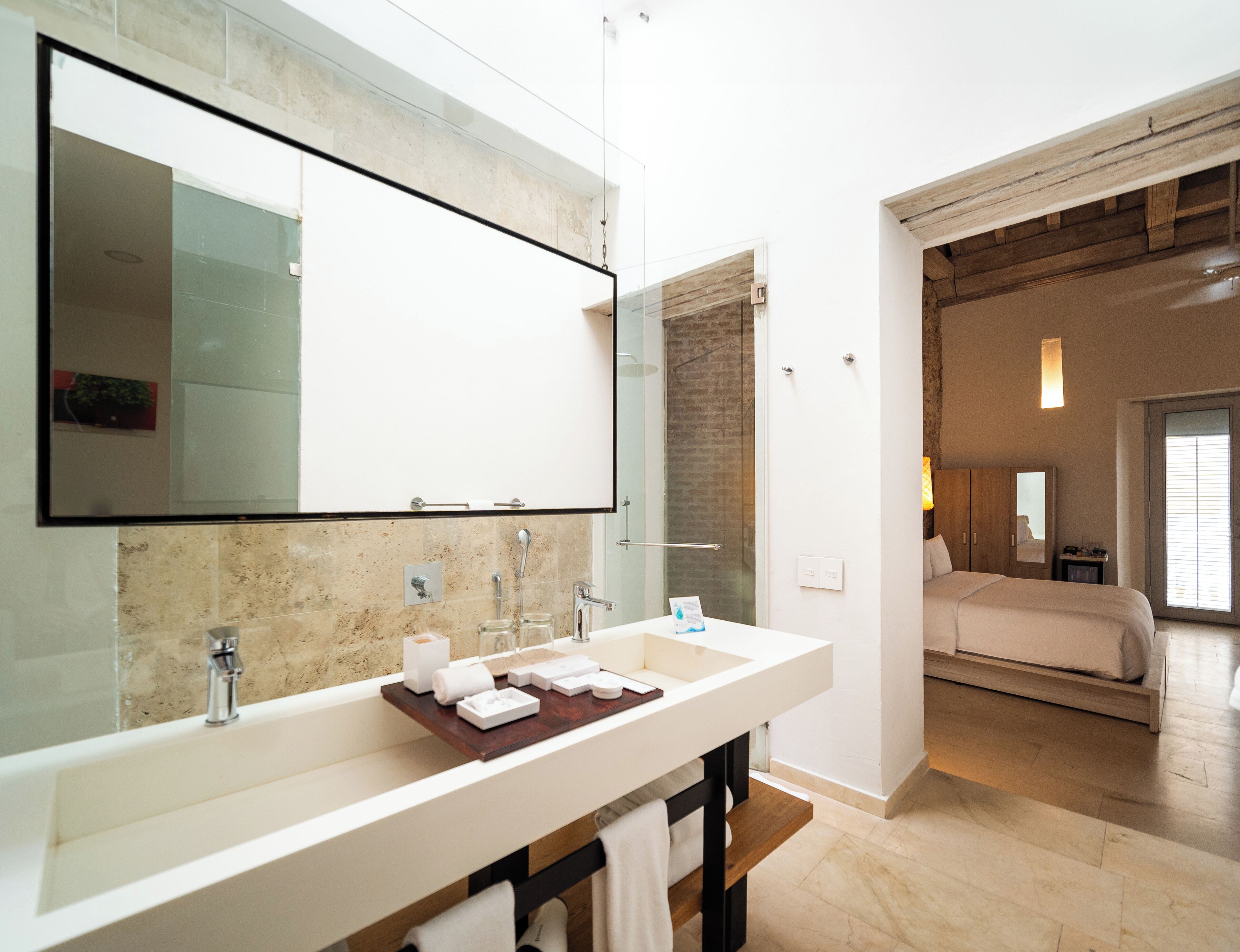 Un baño moderno con un espejo grande, un lavamanos blanco y un mueble de tocador de madera.