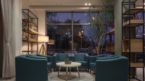 Una sala de estar moderna con sofás color turquesa, una mesa de centro redonda y estanterías empotradas.