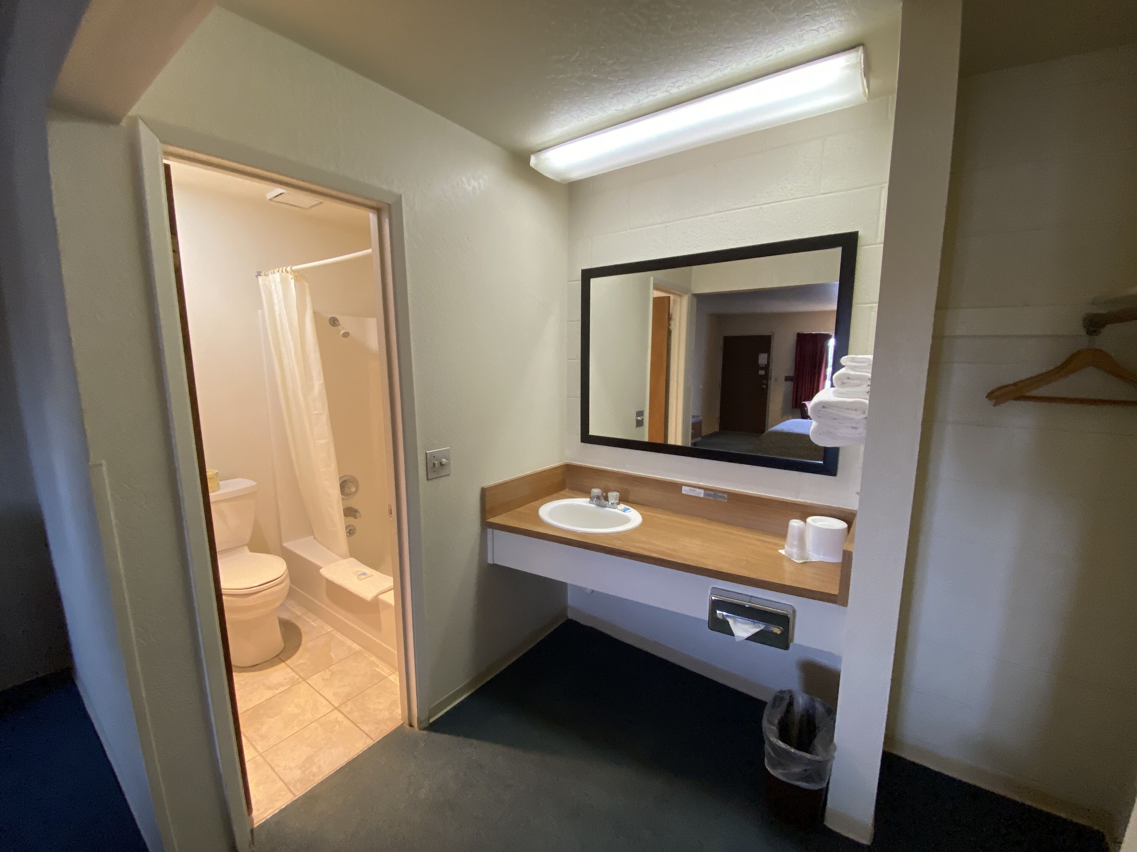 Une salle de bain d’hôtel équipée de toilettes, d’un lavabo, d’un miroir et d’une douche.