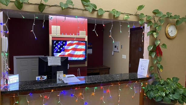Un comptoir d’accueil orné d’un drapeau américain, d’une horloge et de décorations de fêtes.