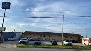 A parking lot with several vehicles, a U-Haul truck, and a Newton Inn sign.