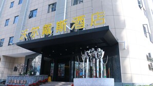 A hotel entrance with a sign in a foreign language, a covered entrance area, and a display of various items. - Days Inn Fuzhou Woer (Fuzhou)