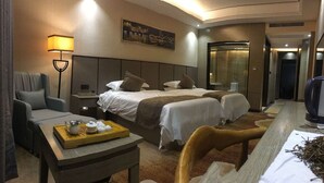 A hotel room with two beds, a desk with a tray of tea, a chair, a lamp, and a painting on the wall. - Days Inn Fuzhou Woer (Fuzhou)