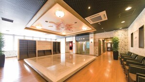 A spacious lobby with a central island, wooden flooring, and a ceiling with decorative lighting. - Hotel WBF Grande Asahikawa (Asahikawa)