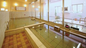 A public bath area with a glass enclosure, tiled floor, and a view of the outside through large windows. - Hotel WBF Grande Asahikawa (Asahikawa)