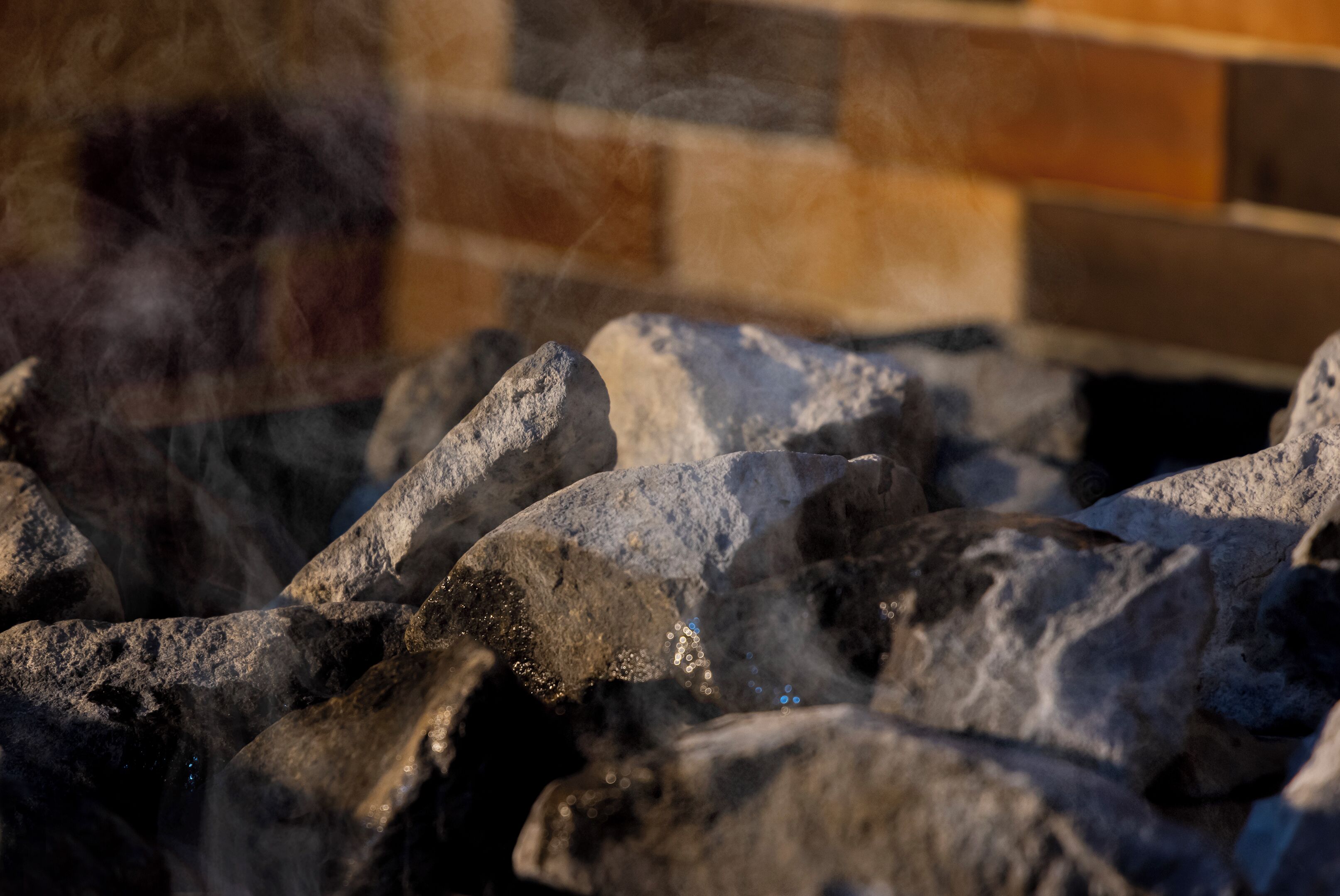 Primer plano de una chimenea de piedra con humo elevándose.