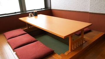 A room with a wooden table and four red cushions.