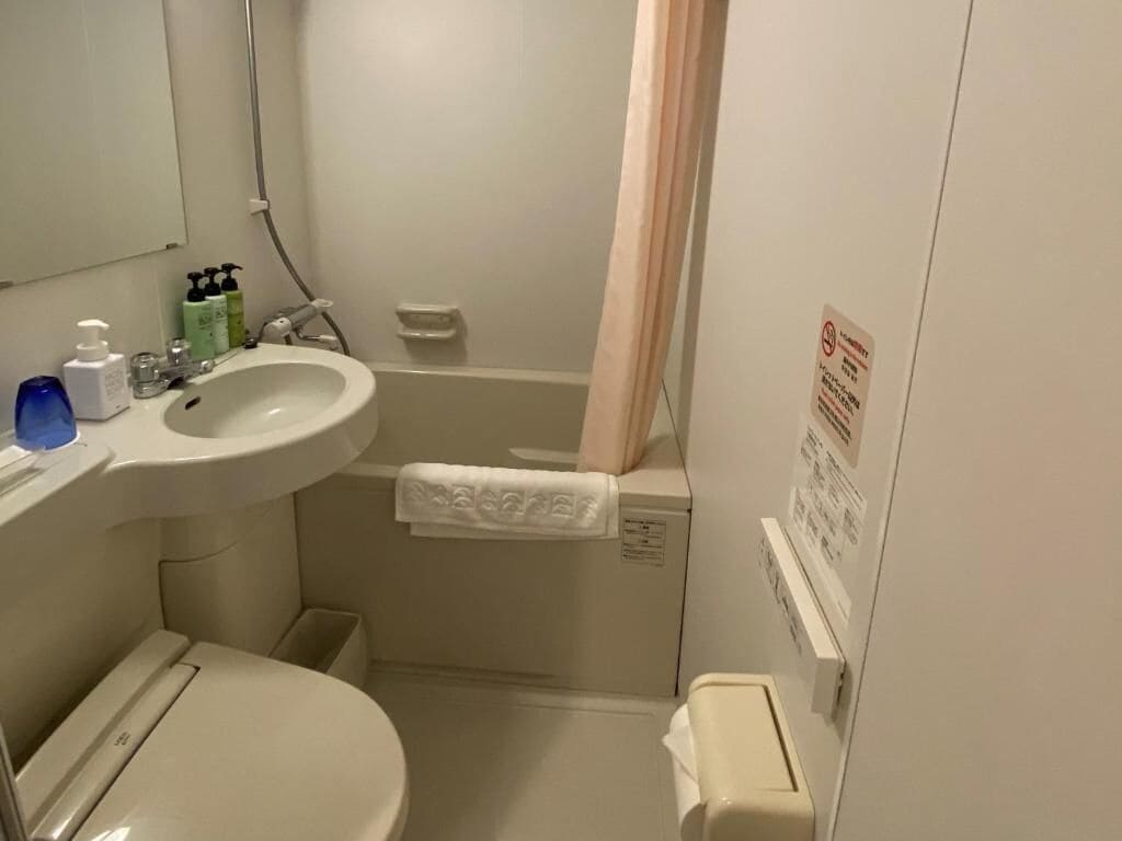 Une salle de bain équipée de toilettes, d’un lavabo et d’une douche.