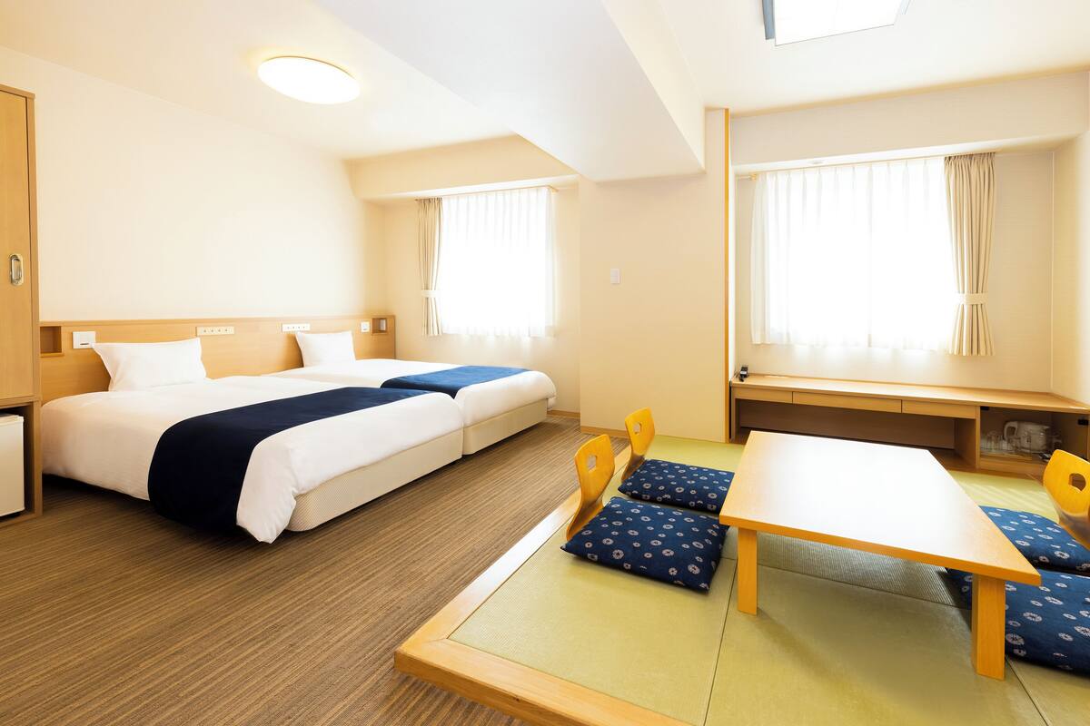 Une chambre d’hôtel avec un grand lit, un bureau et une chaise.