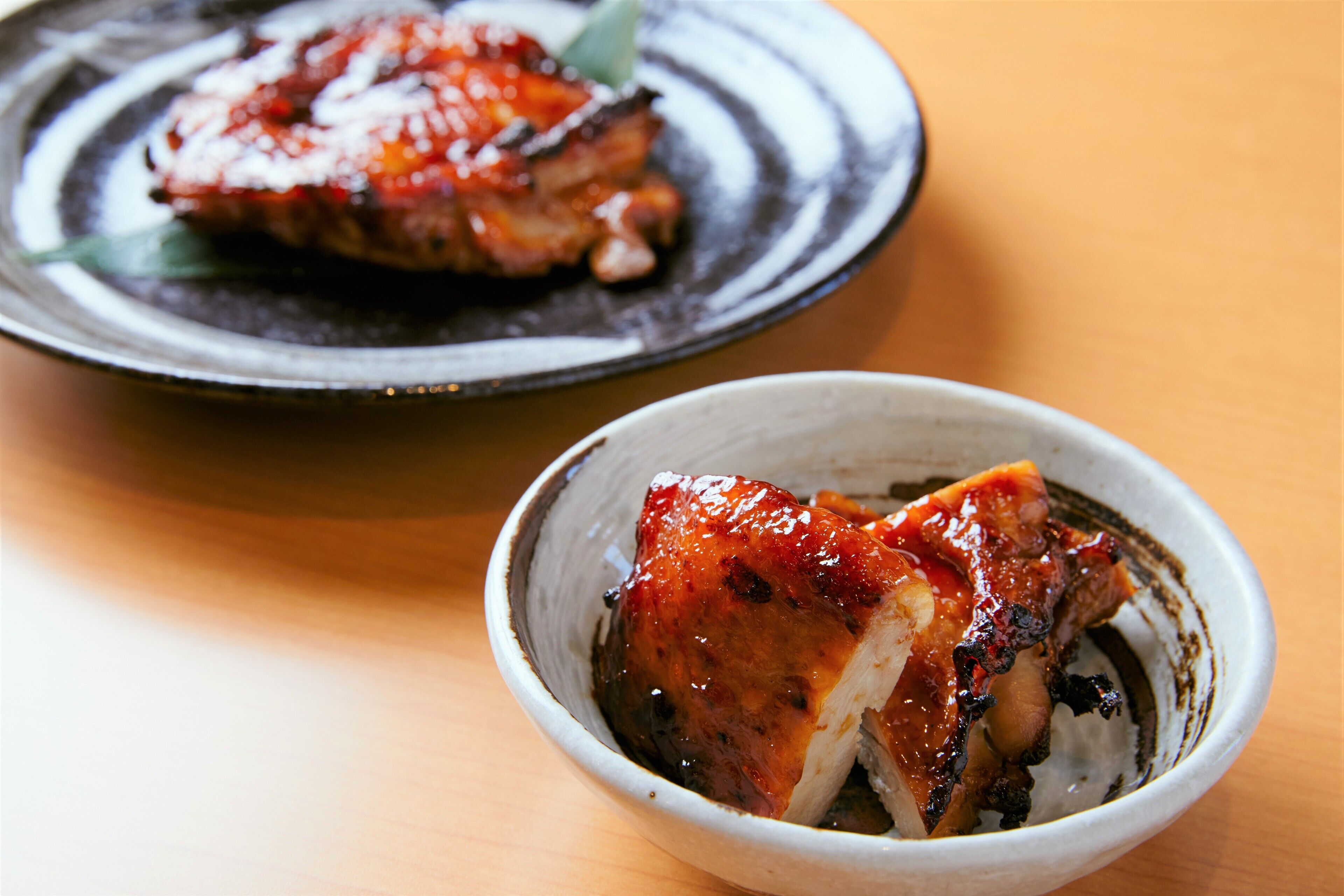 A bowl of food with a piece of meat and sauce.