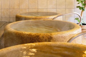 Uma área de spa com três banheiras de hidromassagem de pedra.