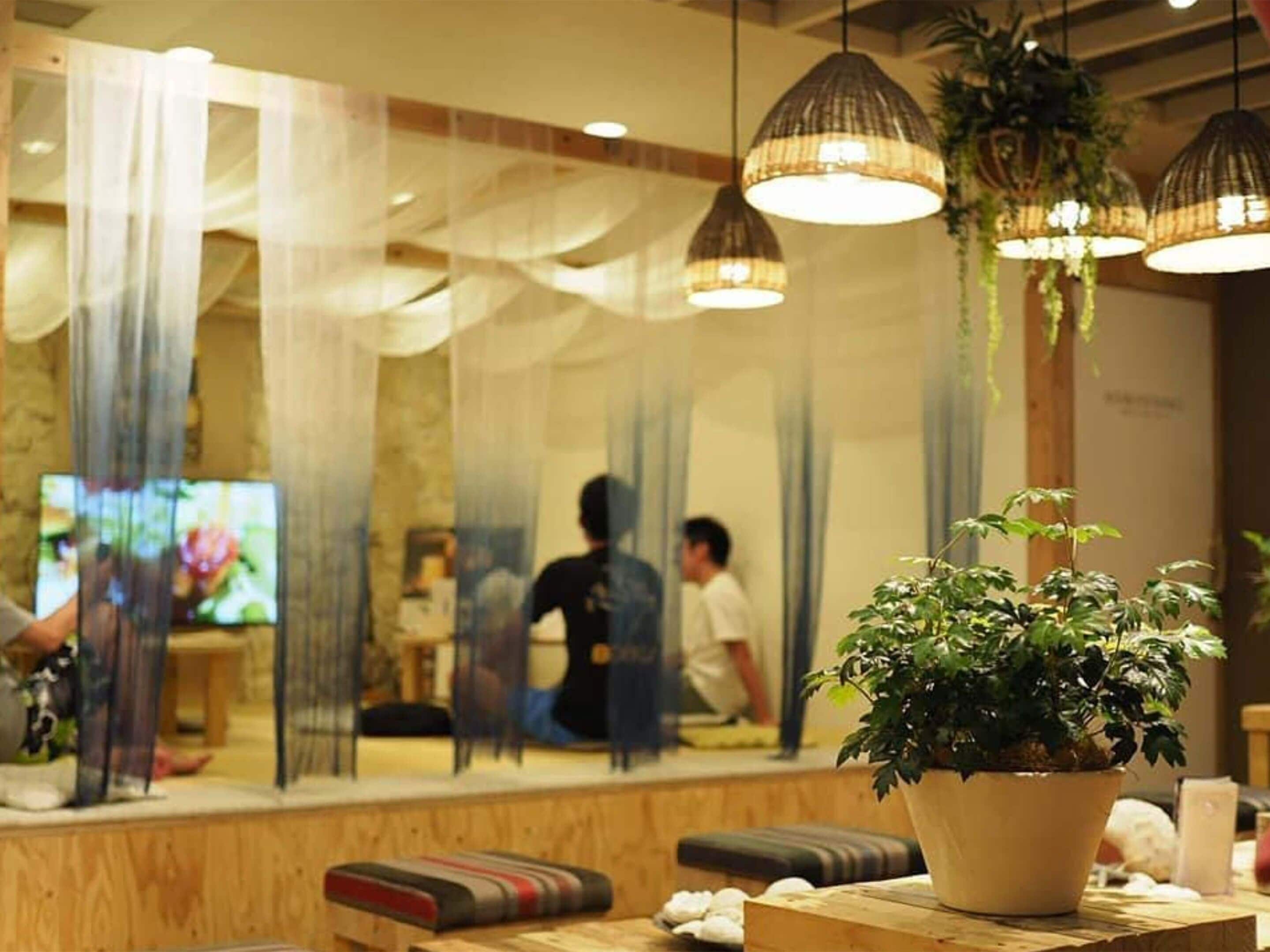Ein modernes Interieur mit Holzmöbeln, einem großen Spiegel, der den Raum widerspiegelt, und hängenden Pendelleuchten.