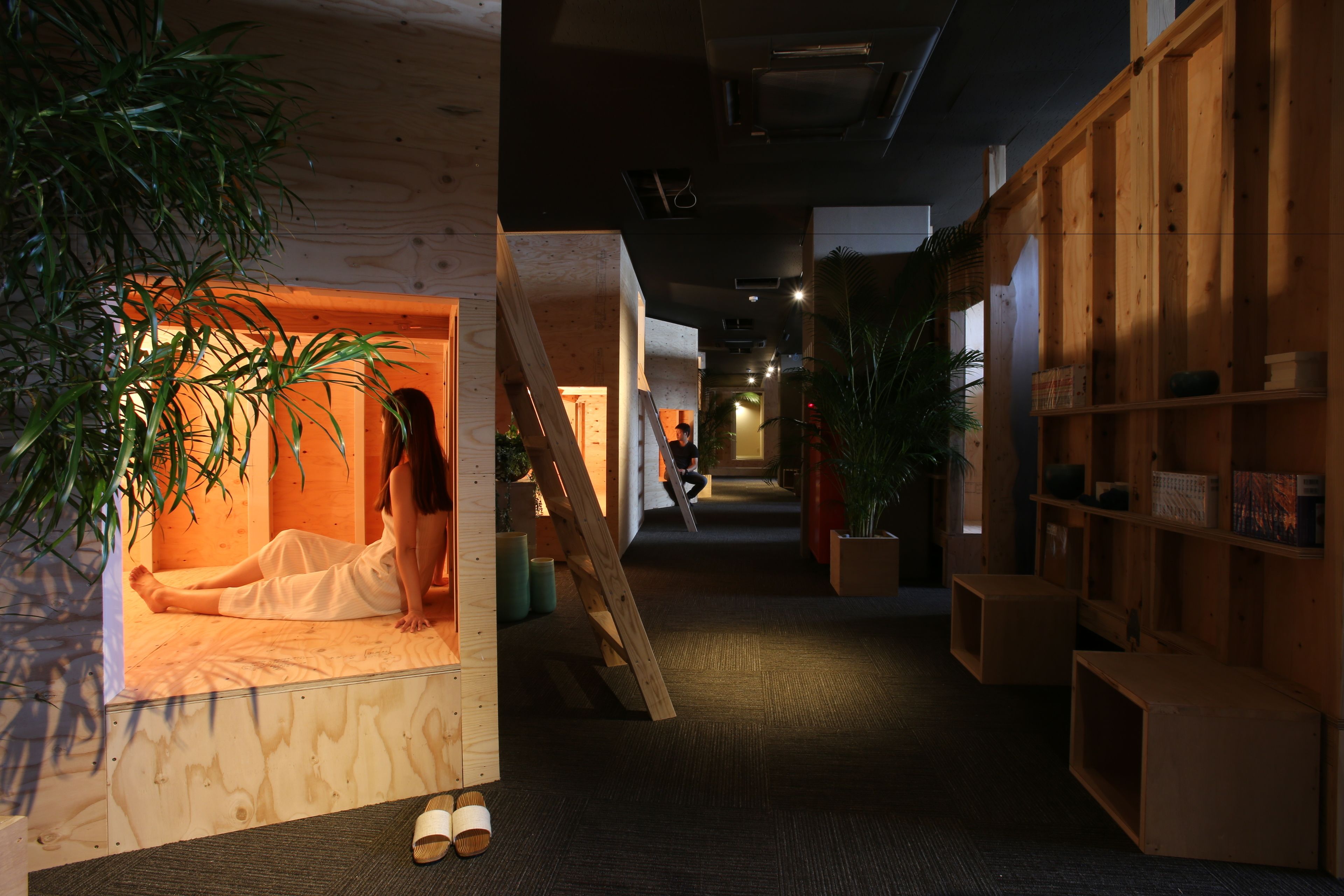 A hallway with wooden walls, a wooden bench, and potted plants.