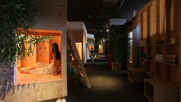 A hallway with wooden walls, a wooden bench, and potted plants.