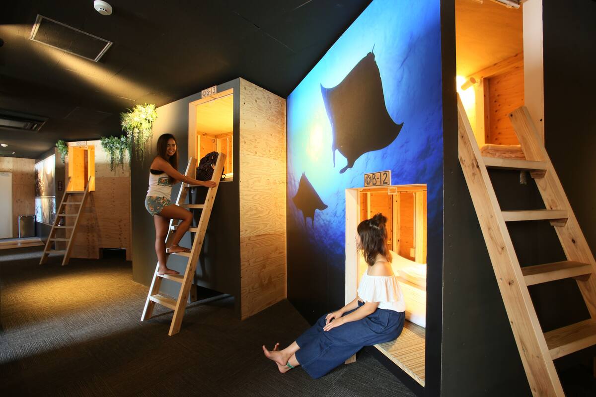 Ein Zimmer mit einer Holzleiter, einer Holzwand mit einer Silhouette und einer Person, die auf dem Boden sitzt.