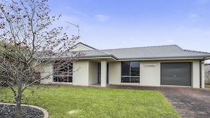 A modern building with a flat roof, a garage, and a well-maintained lawn.