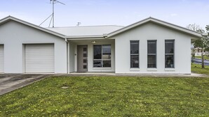 A modern two-story house with a garage, a covered entryway, and a large windowed front section. - Megan Court Apartments (Mount Gambier)