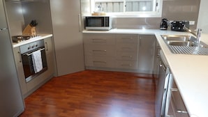 A modern kitchen with a built-in oven, microwave, and coffee maker. - Hart Street Apartment (Mount Gambier)