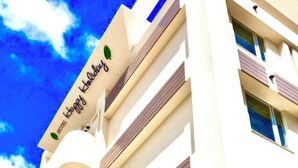A hotel sign with the text "Happy Holiday" and a leaf logo. - Hotel Happy Holiday Ishigakijima (Ishigaki)