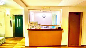 A reception area with a reception desk, a clock, and a door labeled "FRONT".