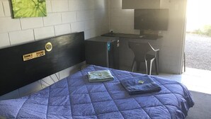 Une chambre avec un lit, un bureau et un téléviseur.