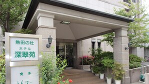 A hotel entrance with a signboard, potted plants, and a tiled walkway. - Hotel Shinsuien (Nagoya)