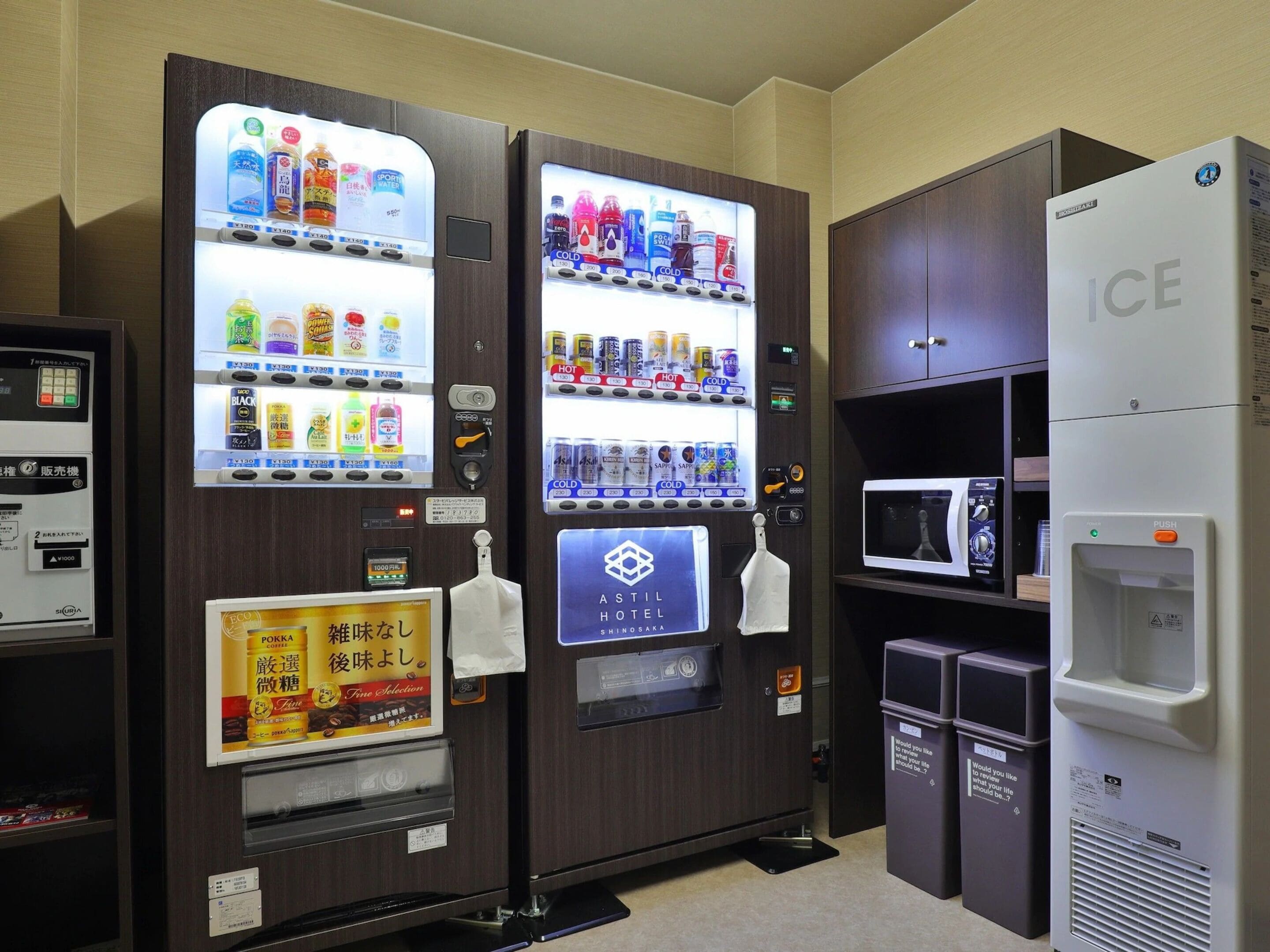 Máquina expendedora con bebidas y aperitivos, microondas y refrigerador con la etiqueta 'ICE'.