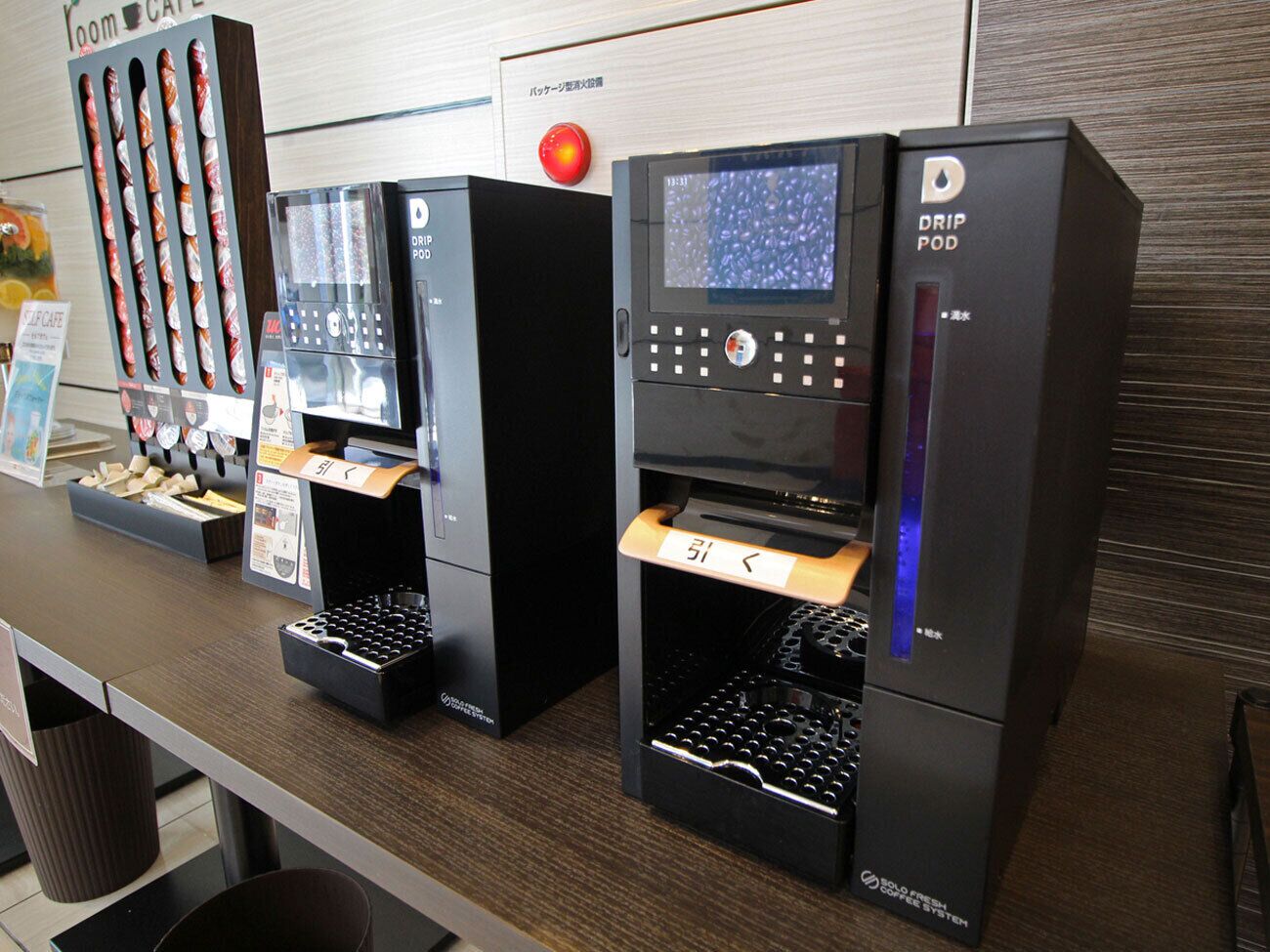 Three drip coffee machines with control panels and drip pods on a counter.