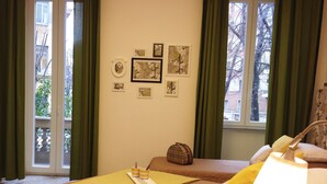 Una habitación de hotel con dos camas, una ventana con cortinas y decoración en la pared.