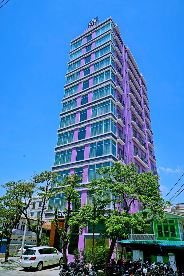 A tall, multi-story building with a purple facade and numerous windows. - Myat Nan Yone Hotel (Mandalay)