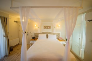 Una habitación de hotel con una cama grande, una mesita de noche y un cuadro colgado en la pared.