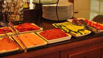 Una mesa de buffet con diferentes alimentos y utensilios para servir.