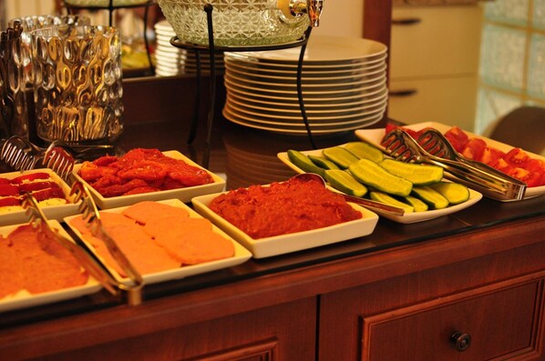 Una mesa de buffet con diferentes alimentos y utensilios para servir.