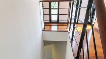 A wooden staircase with a metal railing leading to an upper level.