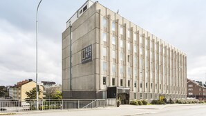Un immeuble moderne avec une enseigne indiquant : « BIZ APT HOTEL APARTMENTS ».