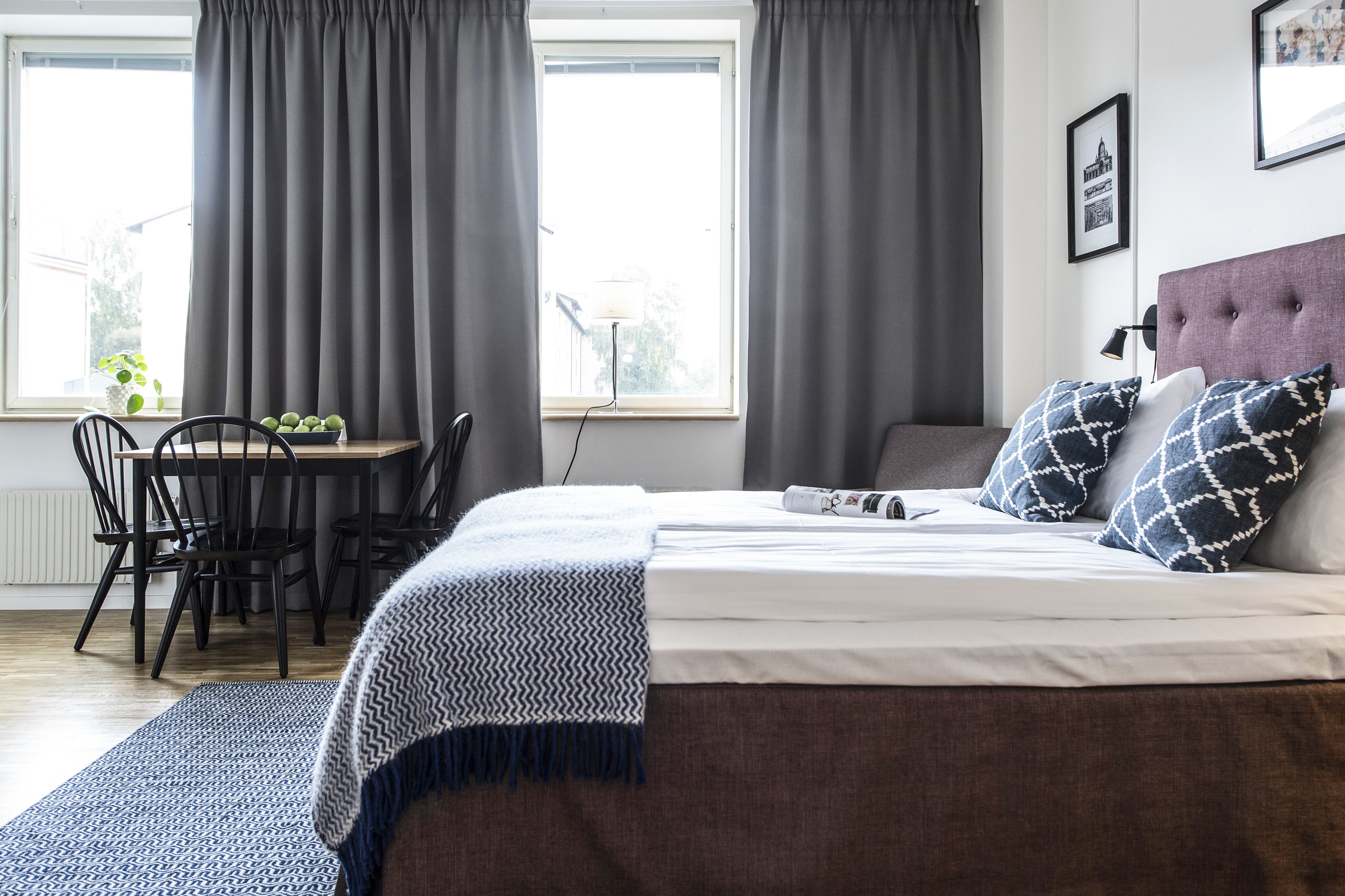 A bedroom with a bed, a desk, and a chair.