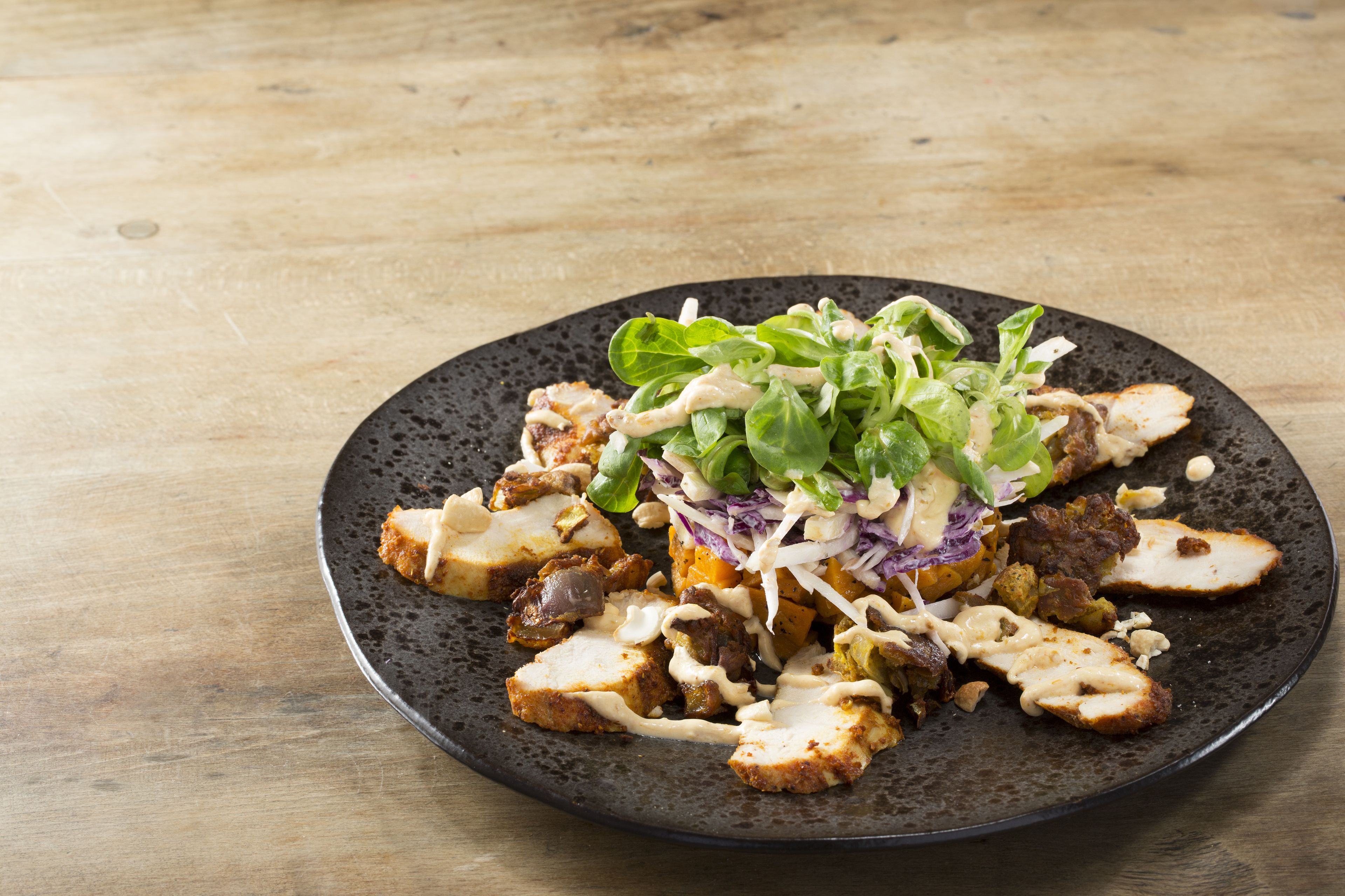 A plate of food with various toppings and a creamy sauce.