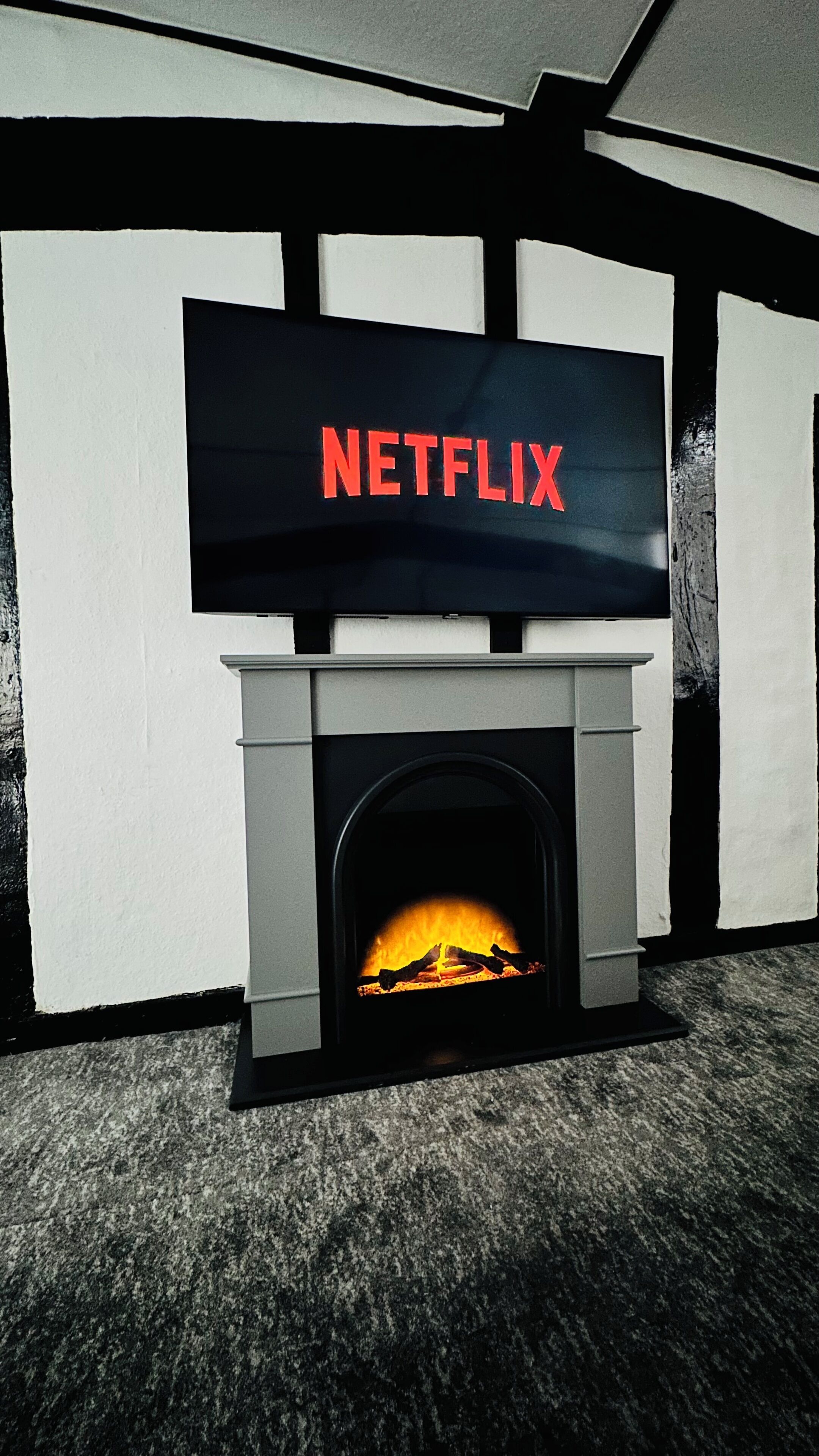 Une cheminée avec un écran de télévision affichant le logo de Netflix.