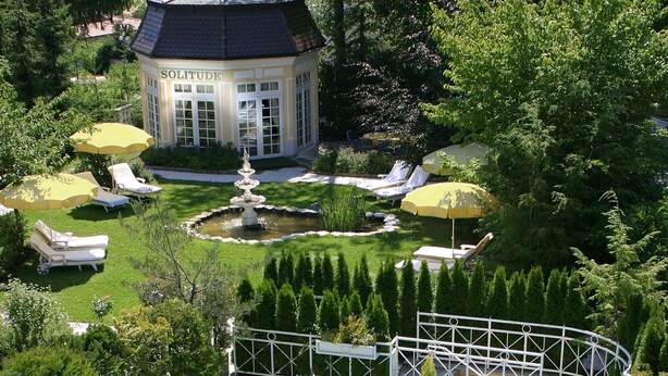 Ein luxuriöser Außenbereich mit Swimmingpool, Liegestühlen und einem Pavillon.