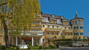 Ein Hotel mit mehreren Balkonen, einer Fontäne und einem Turm.