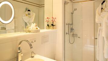 A modern bathroom with a sink, mirror, and shower.