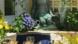 Ein Tisch, gedeckt für eine Mahlzeit, mit einer Statue im Hintergrund.