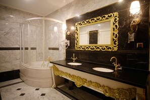 Deluxe suite (King) | Badkamer | Een bubbelbad, gratis toiletartikelen, een haardroger, badjassen