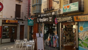 Una vista de carrer amb un restaurant anomenat 'El Mentidero' i una papereria.