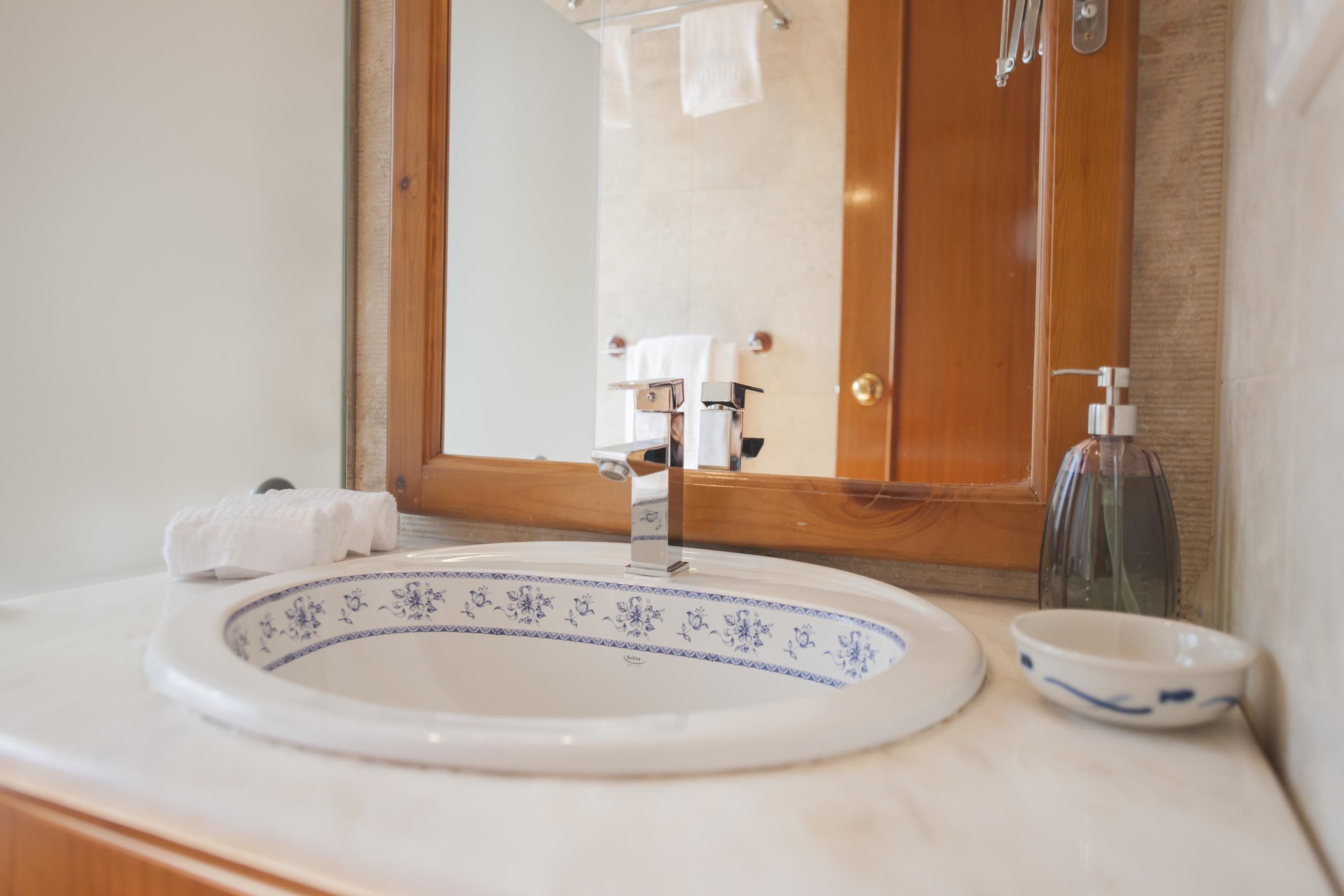 A bathroom with a white sink, a mirror, and a wooden door.